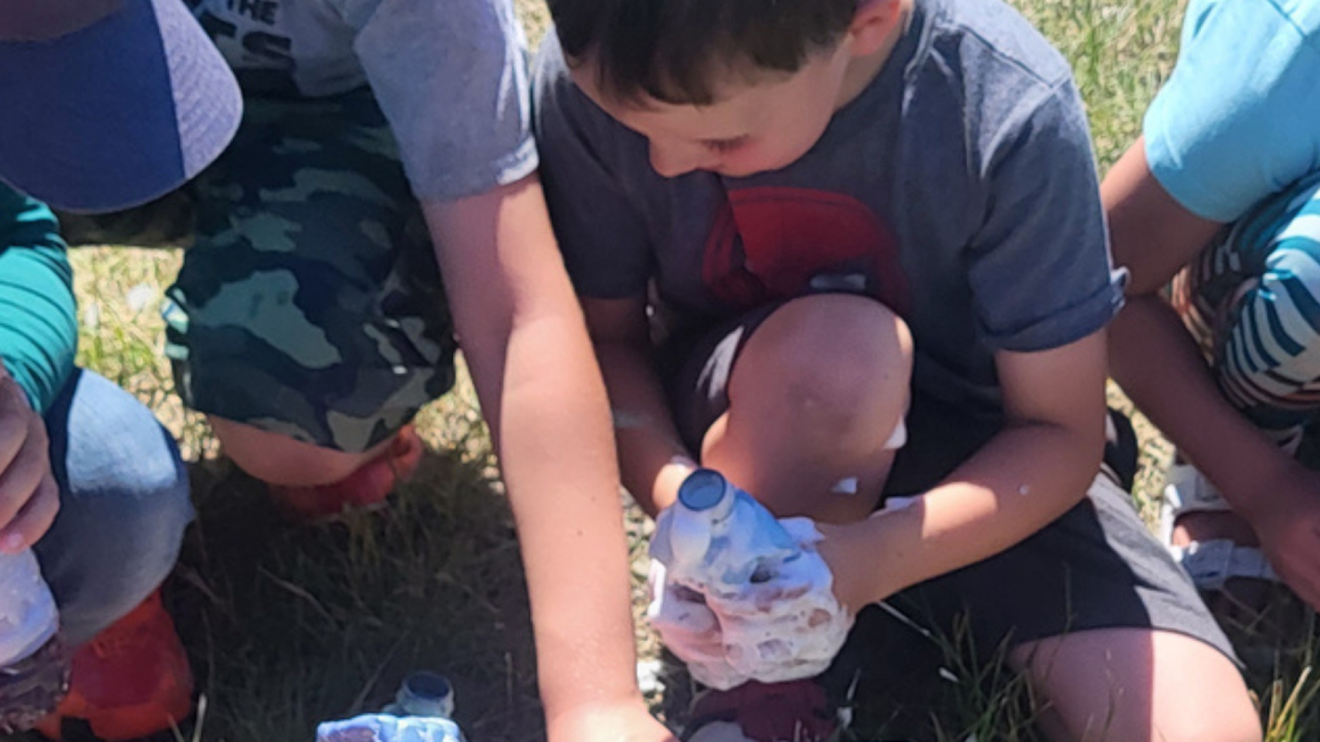 Kids doing science experiments outside.