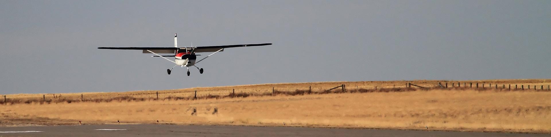 Small plane landing on runway.
