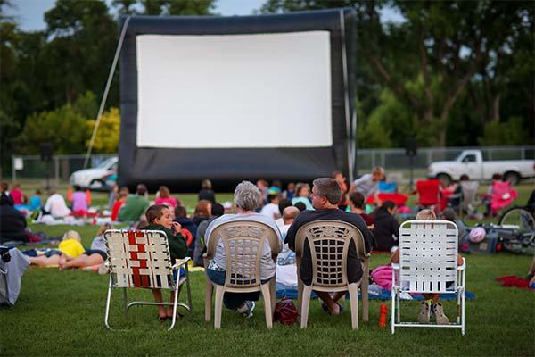 Crowd watching a movie at a park.